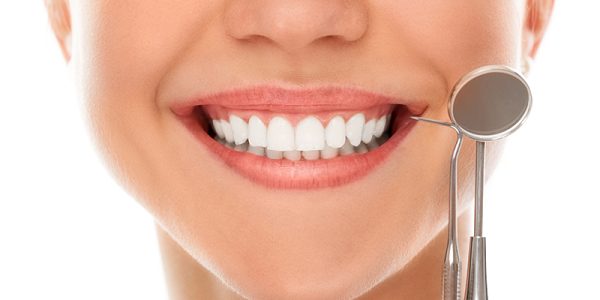 A woman is smiling while being at the dentist